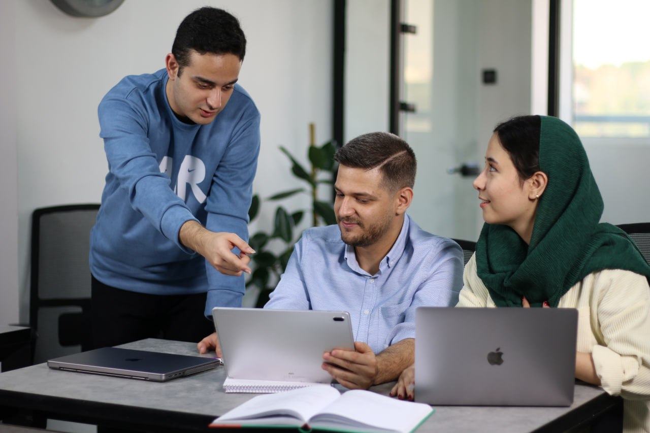 همکاری تیم نویش دور یک میز کار